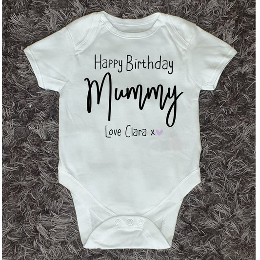 White baby vest with black text 'Happy Birthday Mummy Love Clara' (Text can be changed) followed by a Purple Heart