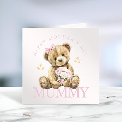 Mother’s Day Card featuring the text ‘Happy Mother’s Day Mummy’ in pink writing and a teddy bear holding a bouquet of pink flowers. Other images show the text in blue, and different name variations ie Mammy, Granny.